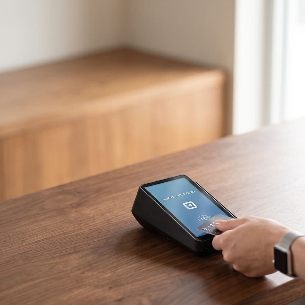 A customer tapping their card on a Square terminal